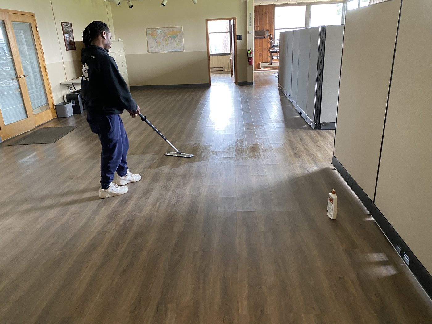 An E&L cleaner mopping the floor of a bright open-plan office in Essex County, NJ